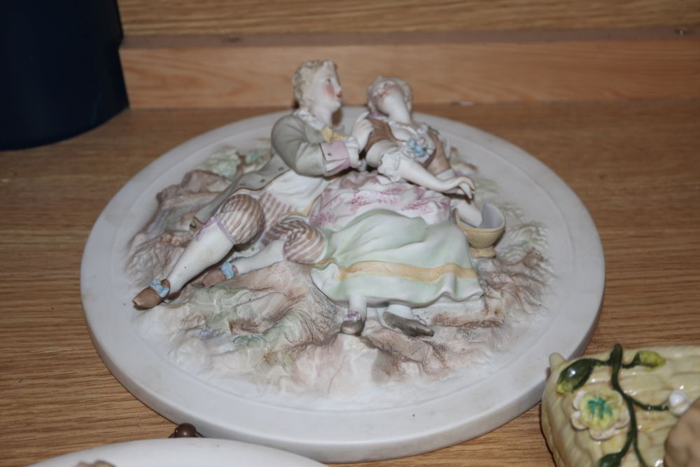 A group of Continental porcelain wall plaques and pockets and a figure group